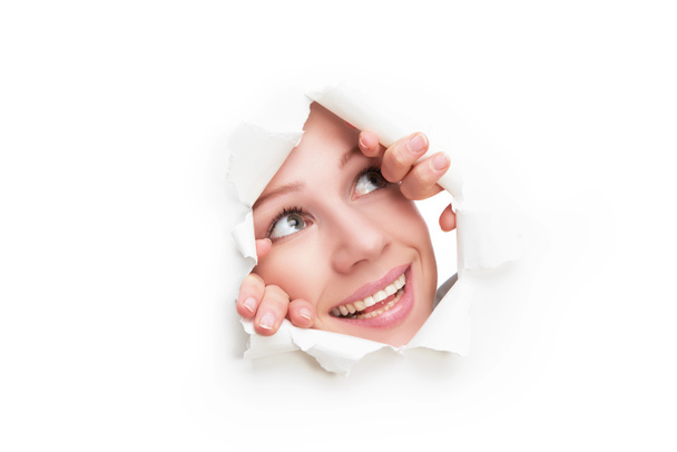 visage de femme regardant à travers un trou déchiré dans l'affiche en papier blanc
 - Photo, image