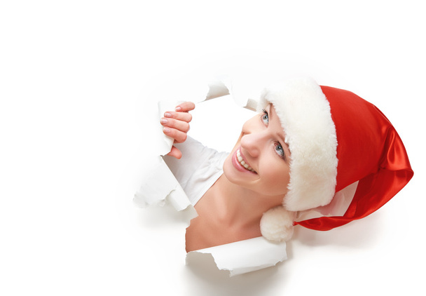 felice donna con cappello di Natale sbirciando attraverso un buco strappato nel poster di carta bianca
 - Foto, immagini