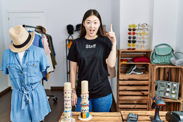 小売店のマネージャーとして働いている若いアジアの女性は、成功したアイデアで指を指しています。興奮して幸せよ。第1位.  - 写真・画像