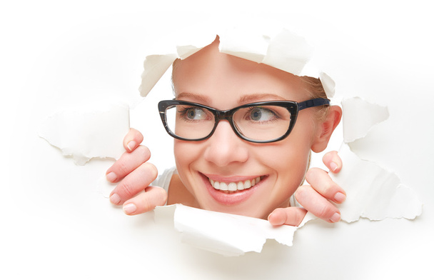 volto di donna in occhiali sbirciando attraverso un buco strappato nel manifesto di carta bianca
 - Foto, immagini