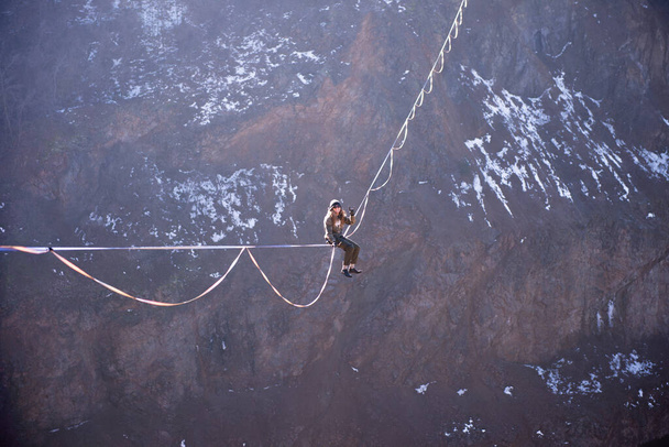 Dobrodruh sedí na vrcholku vysočiny nad krásným jezerem - Fotografie, Obrázek