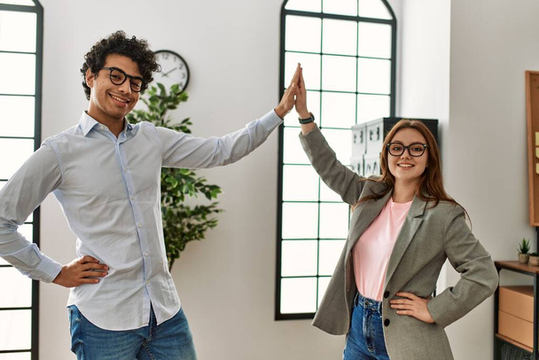 Two business workers smiling happy high five at the office. - Foto, afbeelding
