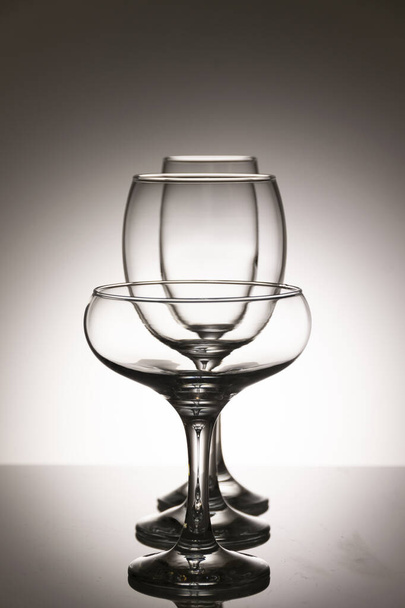 Glassware of different sizes against monochrome background - Foto, Imagen