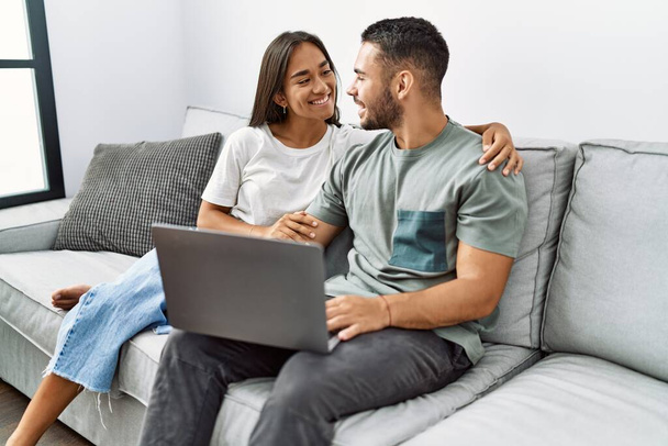 Young latin couple smiling happy using laptop at home. - Foto, afbeelding