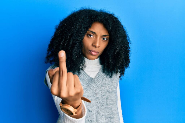 African american woman with afro hair wearing casual winter sweater showing middle finger, impolite and rude fuck off expression  - Fotó, kép