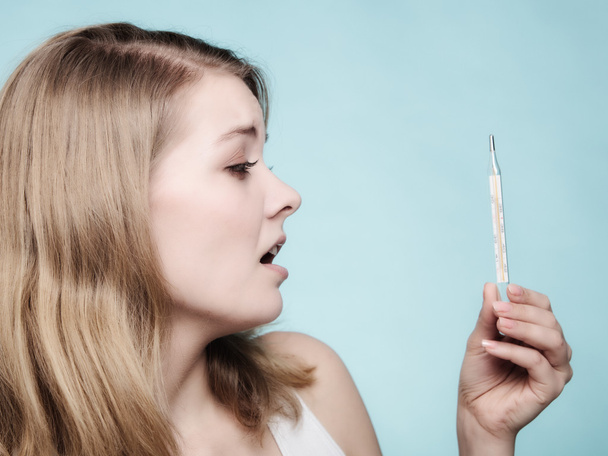 Sick girl checking thermometer - 写真・画像