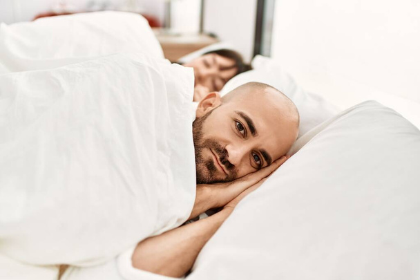 Young hispanic couple sleeping on the bed at bedroom. - Zdjęcie, obraz