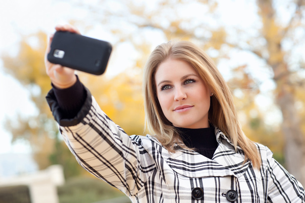 Досить молода жінка знімається з телефоном камери
 - Фото, зображення