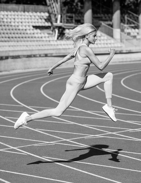 woman with sexy fitness body in sportswear running on stadium, marathon - Valokuva, kuva