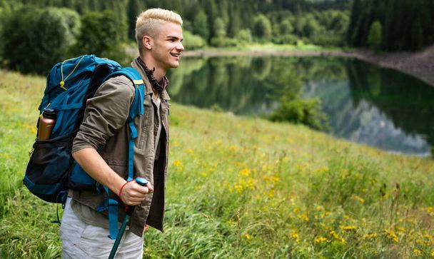 Active healthy young man hiking in beautiful nature. Outdoor activity, sport conecpt - Фото, зображення
