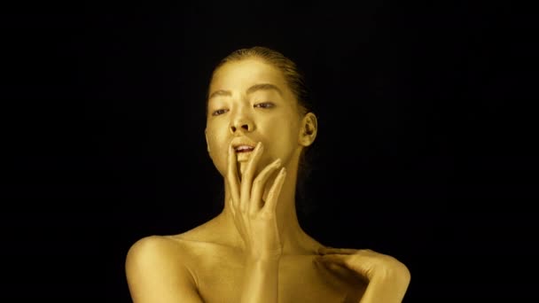 Πορτρέτο της γυναίκας με το χρυσό δέρμα συγκινητικό πρόσωπο, μαύρο φόντο - Πλάνα, βίντεο
