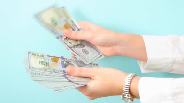 Mädchen zählt Dollar auf blauem Hintergrund in Nahaufnahme. - Filmmaterial, Video
