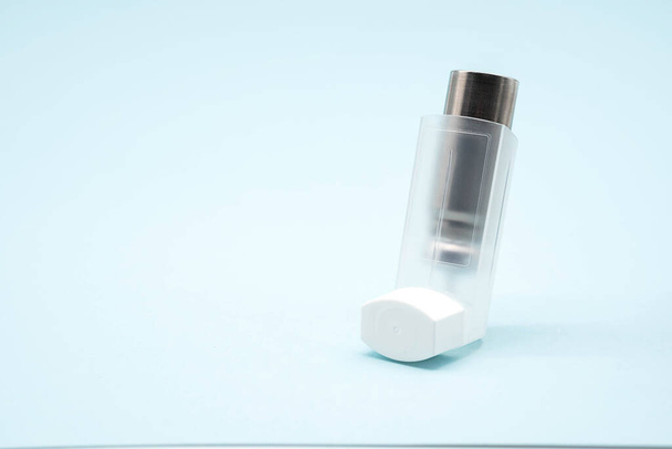 Asthma inhaler on blue background, copy space. Aerosol for inhalation, treatment of bronchial asthma, COPD. Pharmaceutical product for treat lung inflammation and prevent asthma attack.  - Fotografie, Obrázek