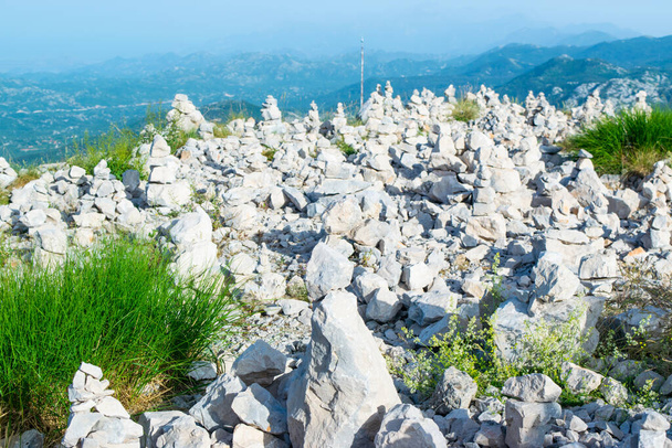 A turisták által készített kőtornyok szerencsét hoznak a Jezerski hegy tetején, a Njegos mauzóleum közelében. Lovcen Nemzeti Park. Montenegró. Nyári kék felső hegyvidéki táj. - Fotó, kép