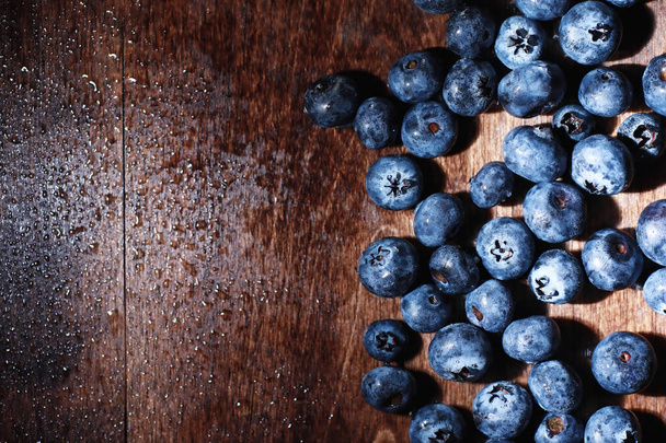 Вода падає на достиглий солодкий чорниця. Свіжі чорниці з копіювальним простором для вашого тексту. Веганська і вегетаріанська концепція. Macro texture of blueberry berries.Texture blueberry berries close up - Фото, зображення