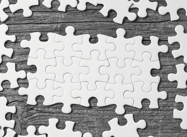 Witte puzzelstukjes op hout - Foto, afbeelding