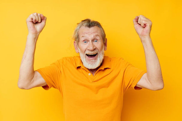 Senior grey-haired man yellow shirt posing emotions isolated background - Fotografie, Obrázek