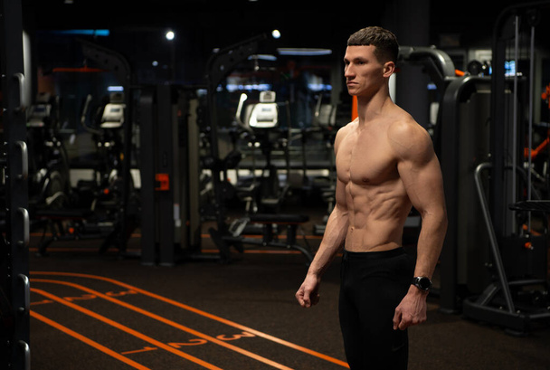 Athletic man with muscular fit torso standing in gym, sportsman - Foto, imagen