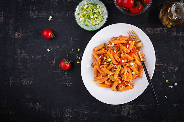 Classic italian pasta penne marinara with mussels and green onions on dark table. Penne pasta with sauce marinara. Top view, overhead - Fotografie, Obrázek
