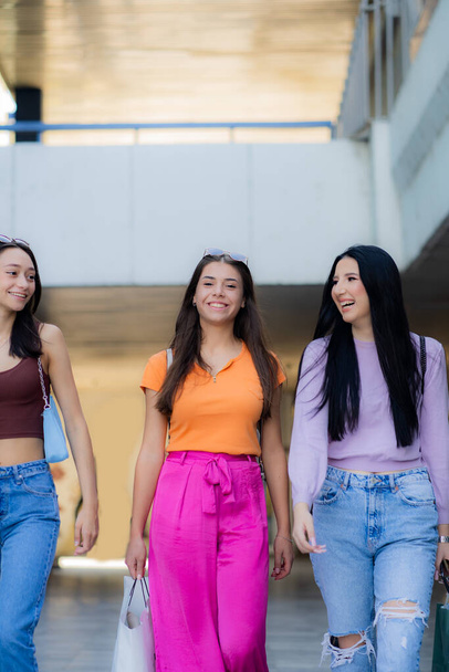 Three beautifula and attractive girls are walking and shopping while smiling - Valokuva, kuva