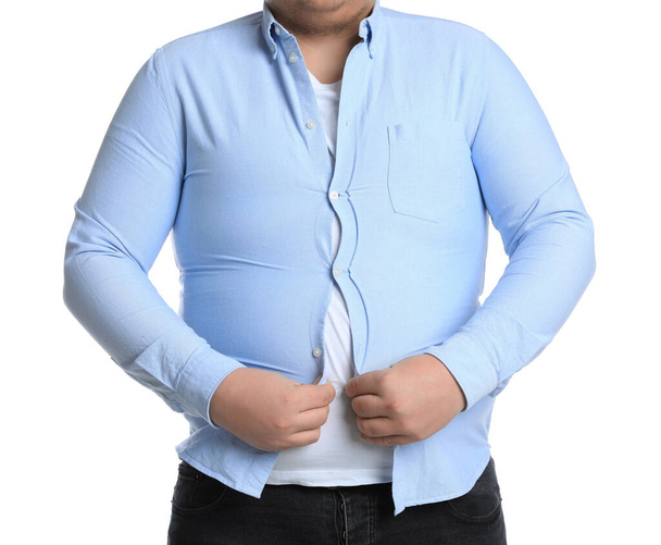 Overweight man trying to button up tight shirt on white background, closeup - Foto, Imagen