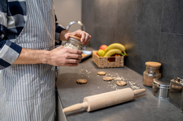 Hands of man in opening jar of almond slices - Foto, imagen