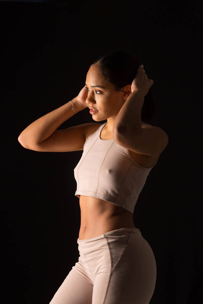 intimate photo of woman in sports clothes on black background - Photo, Image