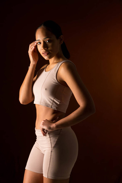 intimate photo of woman in sports clothes on black background - Photo, Image