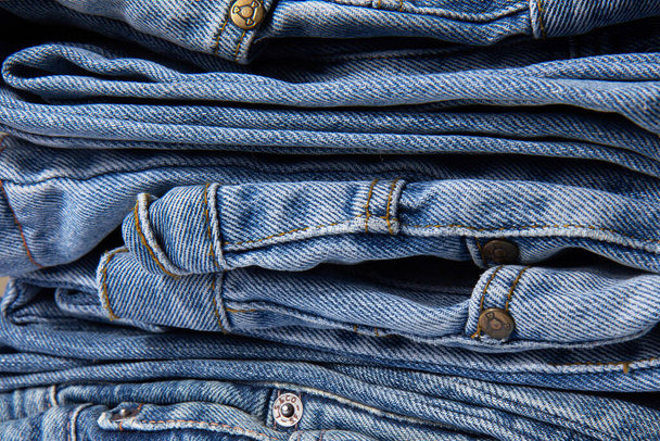 Куча синих джинсов. Абстрактный фон. Задрапированный фон из классической джинсовой ткани, текстуры. Закрыть - Фото, изображение