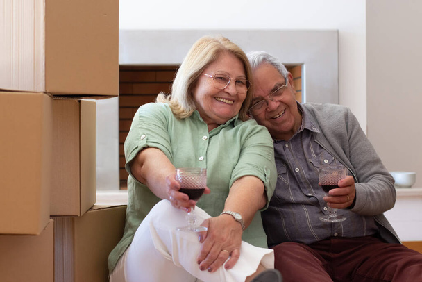 Agradable pareja de ancianos celebrando mudarse a una casa nueva - Foto, imagen