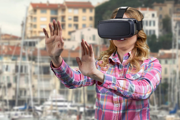 Dziewczyna w okularach VR na tle budynków miejskich. - Zdjęcie, obraz