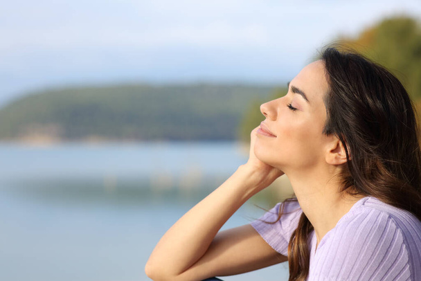 Profile of a happy woman relaxing in a lake - Фото, зображення