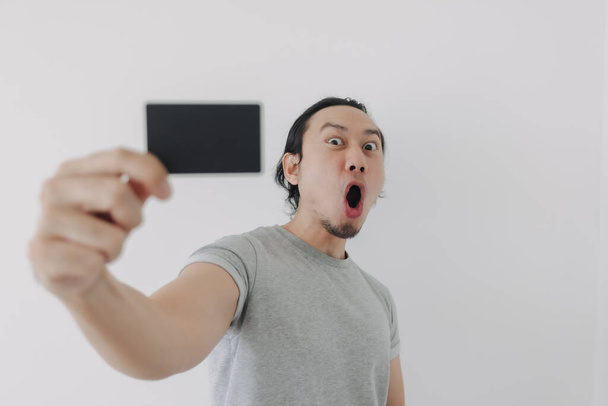 Excited face of man showing black mockup card in his hand. - Fotó, kép