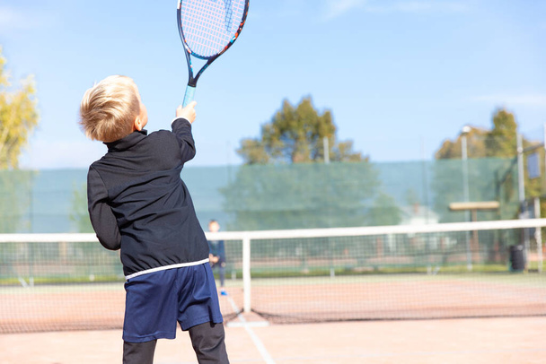 Little boy playing tennis. Tennis training for a child. Tennis lesson forhend beckend. - Fotoğraf, Görsel