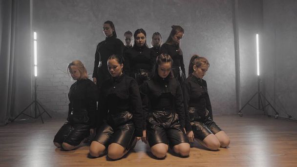 A group of beautiful girls dancing indoors in black suits. Dances - Photo, Image