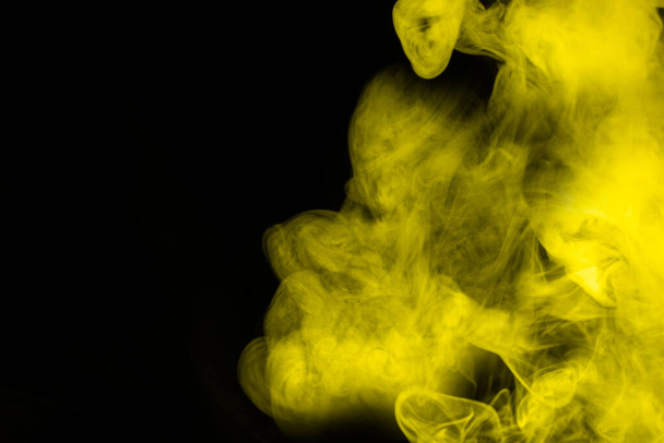 Yellow steam on a black background. Copy space. - Photo, Image