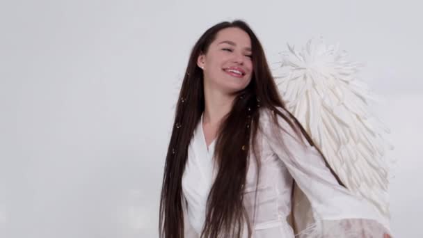 Brunette girl with angel wings dancing on a white background.  - Footage, Video