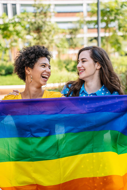Joyeux couple homosexuel diversifié avec drapeau arc-en-ciel - Photo, image