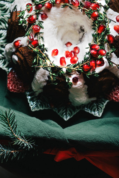 Gâteau Bundt en pain d'épice pour Noël avec des décorations de grenade et de Noël sur fond sombre - Photo, image