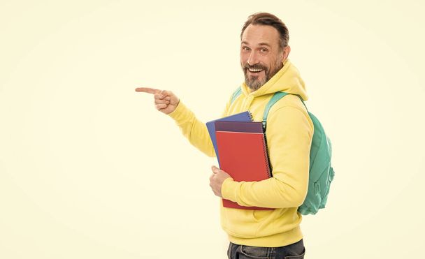 Hombre con capucha amarilla apuntando con el dedo, espacio para copiar. educación literaria para adultos. chico mantenga libro de trabajo. - Foto, Imagen