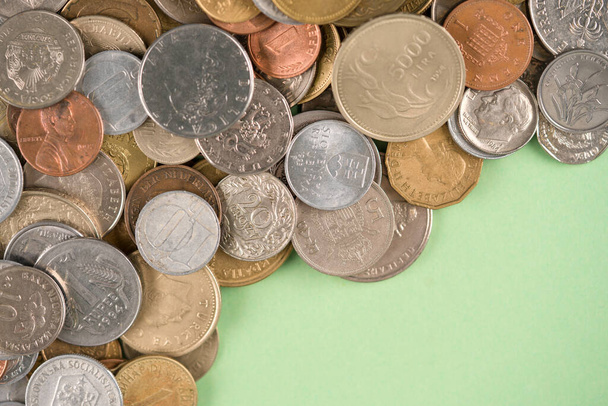 Münzen auf hellgrünem Hintergrund mit Kopierraum. Verschiedene historische Münzen aus aller Welt als Hintergrund. Finanzwachstum und Geschäftskonzept. Numismatik, Münzsammlung - Foto, Bild