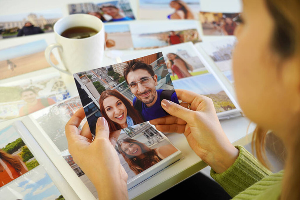 Jovem olhando para as impressões de imagem com seu ex-namorado em casa - Foto, Imagem