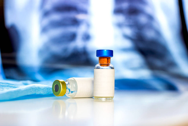 Zwei Impfflaschen mit leerem Etikett auf hellblauem medizinischen Hintergrund mit Kopierraum. Gesundheitsfürsorge, Immunisierung, Virus- oder Infektionspräventionskonzept. - Foto, Bild