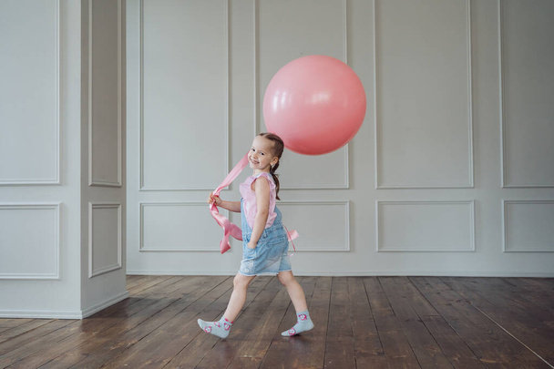 Criança brincando com um balão rosa e espaço de cópia - Foto, Imagem