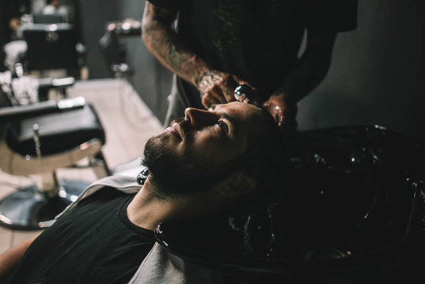 Young man client at barbershop getting haircut hipster - Фото, зображення
