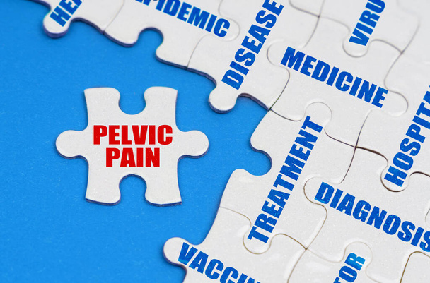 Medicine and health concept. On the blue surface, puzzles with medical inscriptions, on a separate puzzle it is written - PELVIC PAIN - Фото, зображення