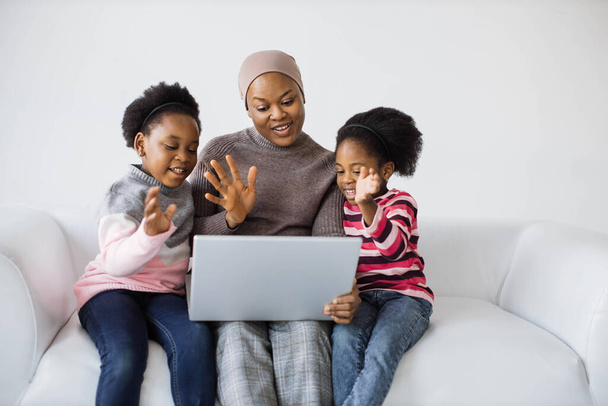 Mother with daughters using laptop for video call - Photo, image