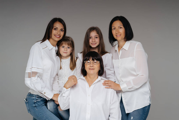 Frauen dreier Generationen posieren auf Grau - Foto, Bild
