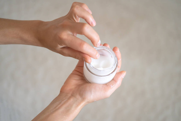 Female hands hold a jar of moisturizing cream. - Φωτογραφία, εικόνα