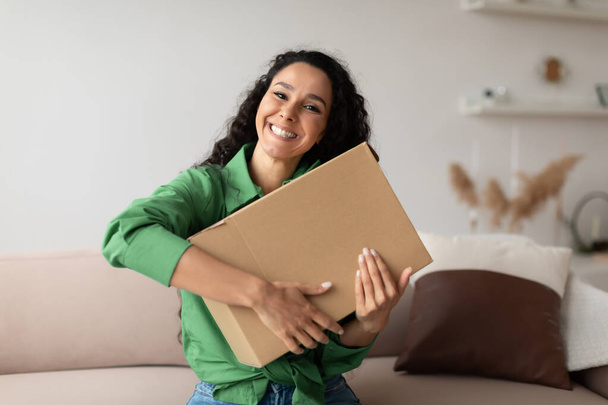 Happy Shopaholic Lady Hugging Box Sitting On Sofa At Home - Foto, Imagen